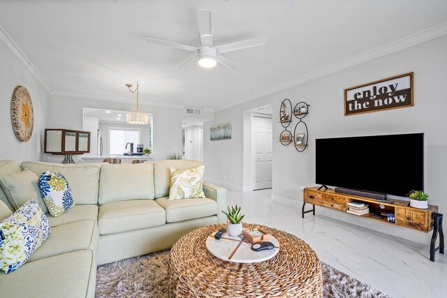 living room with ceiling fan with notable chandelier and crown molding