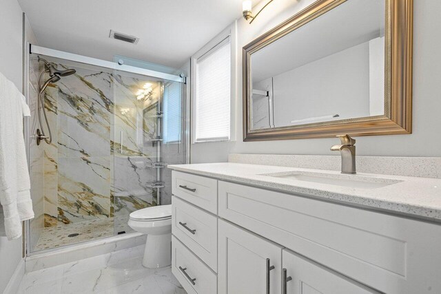 bathroom with walk in shower, vanity, and toilet