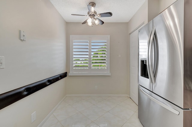 kitchen with stainless steel fridge, a textured ceiling, light tile patterned floors, and ceiling fan