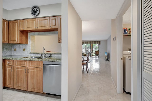 kitchen with dishwasher, sink, tasteful backsplash, washer / dryer, and light tile patterned flooring