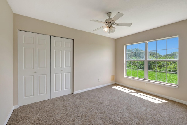 unfurnished bedroom featuring ceiling fan, carpet floors, and a closet