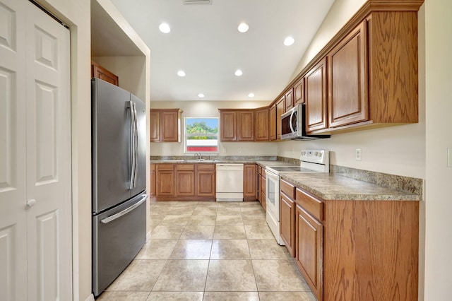 kitchen featuring stainless steel appliances, sink, and light tile patterned floors