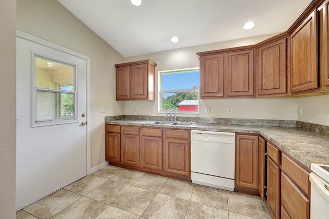 kitchen featuring vaulted ceiling, light tile patterned flooring, sink, and white appliances