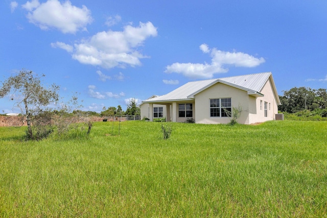 rear view of house with a lawn and central air condition unit