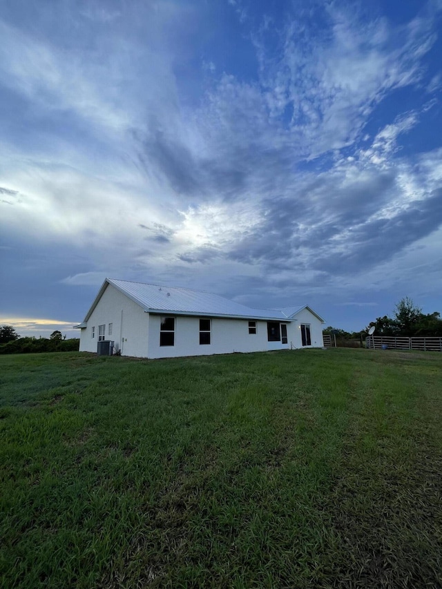 rear view of house with a yard and central AC