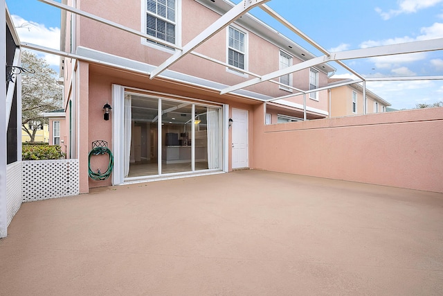 view of patio featuring glass enclosure