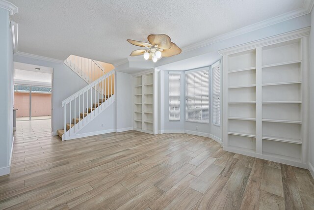 laundry area with washer and clothes dryer, cabinets, a textured ceiling, and light wood-type flooring