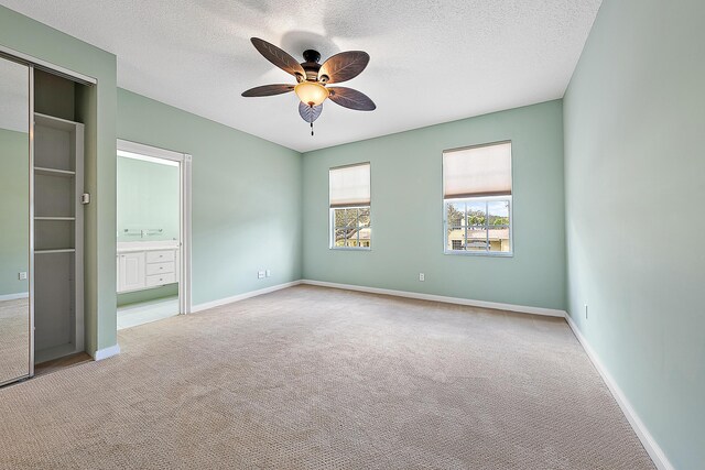 carpeted bedroom featuring ceiling fan and a textured ceiling