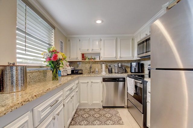 kitchen with tasteful backsplash, stainless steel appliances, ornamental molding, and light tile patterned floors