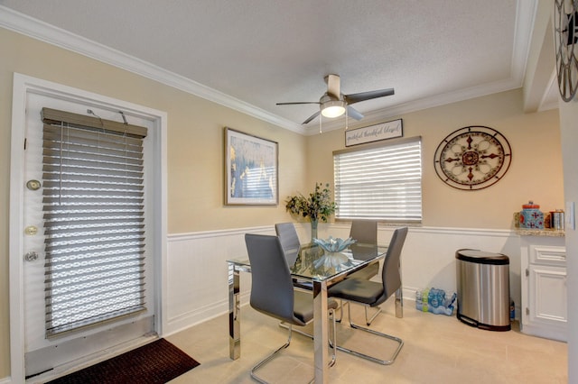 dining area with a textured ceiling, crown molding, and ceiling fan