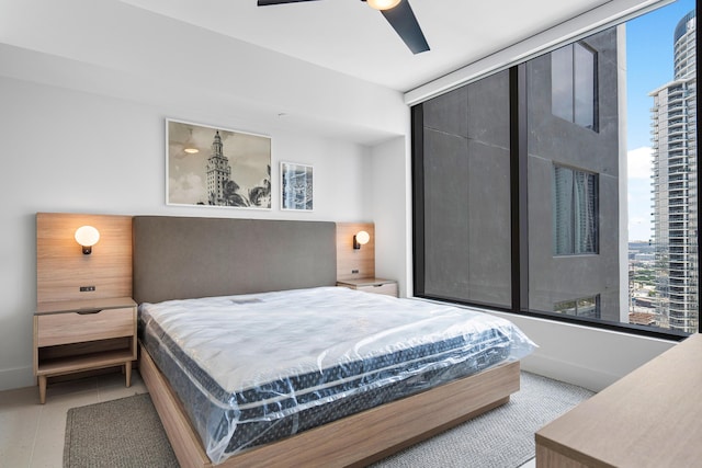 tiled bedroom featuring multiple windows and ceiling fan