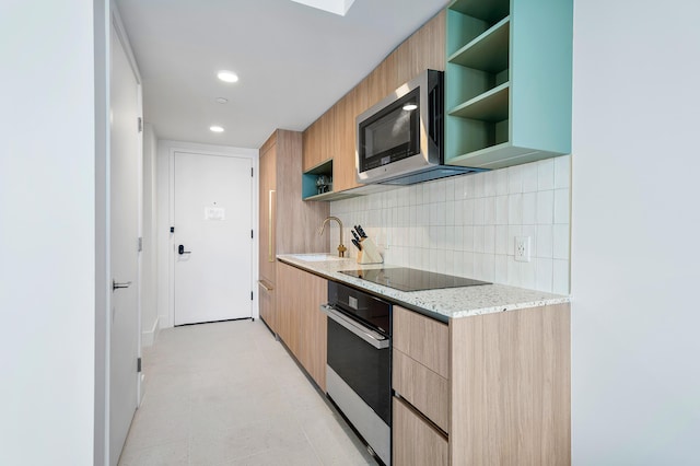 kitchen with light brown cabinetry, sink, decorative backsplash, stainless steel appliances, and light stone countertops