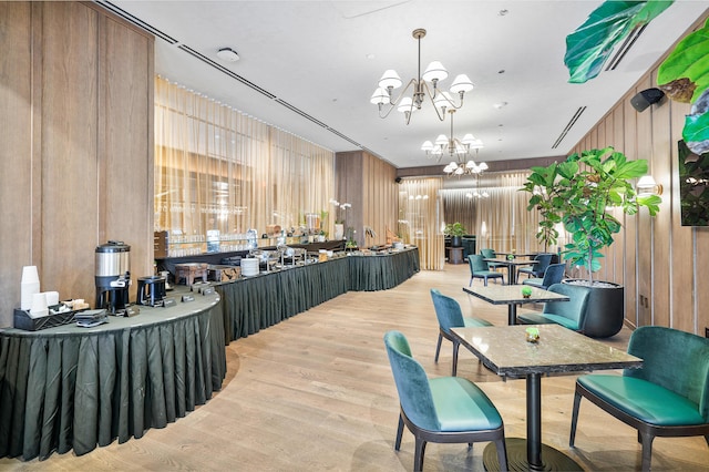 interior space featuring wood walls, a chandelier, and light hardwood / wood-style flooring