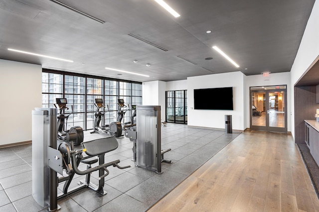 gym featuring floor to ceiling windows and light wood-type flooring