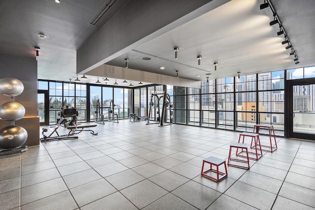 exercise room featuring tile patterned flooring, floor to ceiling windows, a wealth of natural light, and track lighting