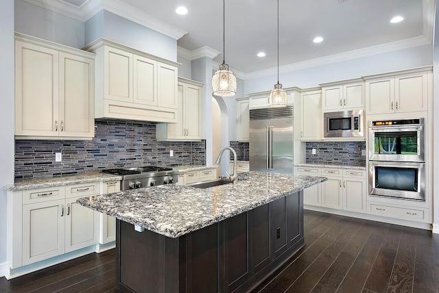 kitchen with backsplash, built in appliances, dark wood-type flooring, and sink