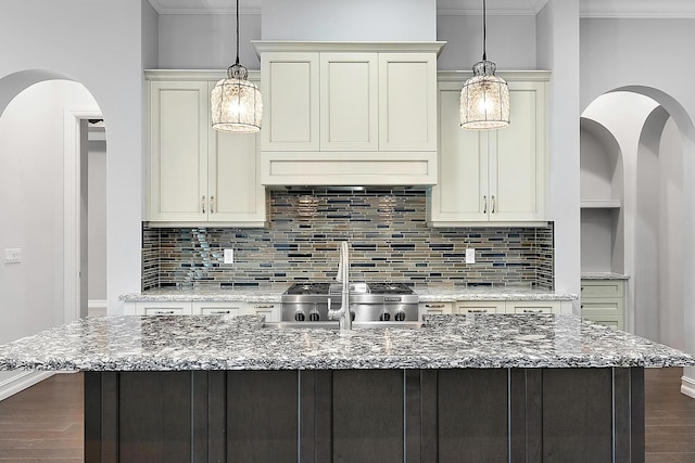 kitchen with hardwood / wood-style floors, crown molding, tasteful backsplash, and light stone counters