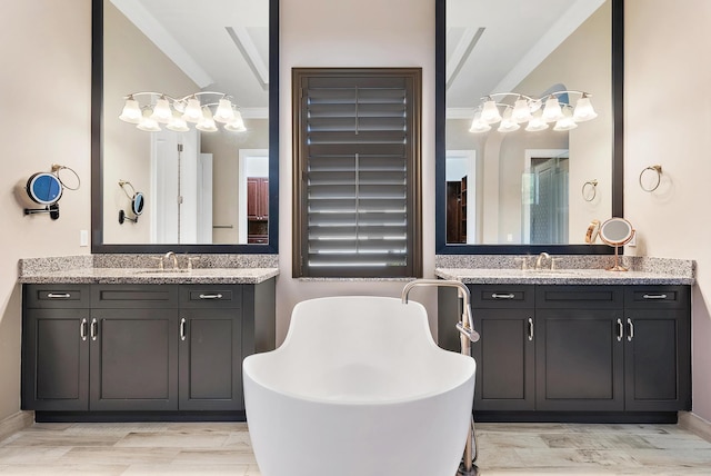 bathroom with crown molding, wood-type flooring, a tub, and vanity