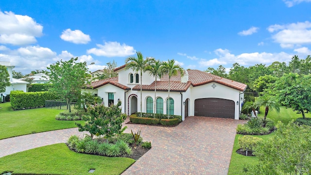 mediterranean / spanish home with a garage and a front yard