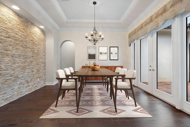 dining space with an inviting chandelier, ornamental molding, dark hardwood / wood-style flooring, and a tray ceiling