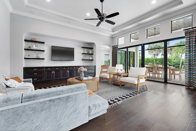 living room with ceiling fan, crown molding, a tray ceiling, and hardwood / wood-style floors