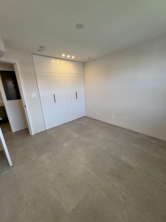 unfurnished bedroom featuring concrete flooring and a closet