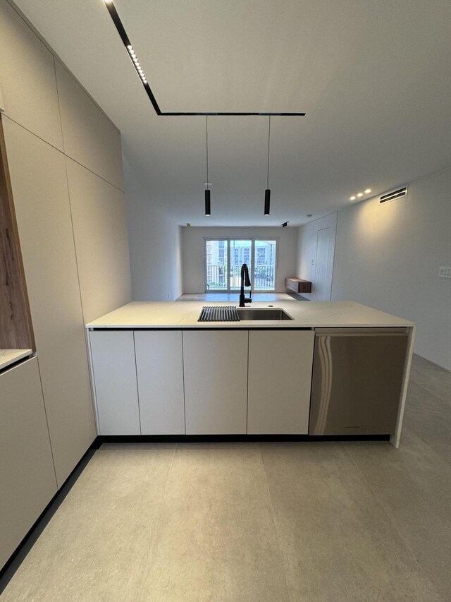 kitchen with white cabinetry, sink, kitchen peninsula, and dishwasher