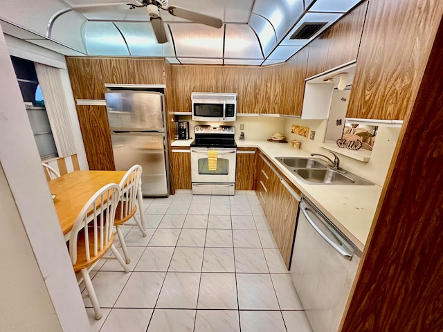 kitchen with stainless steel appliances, ceiling fan, light tile patterned floors, and sink