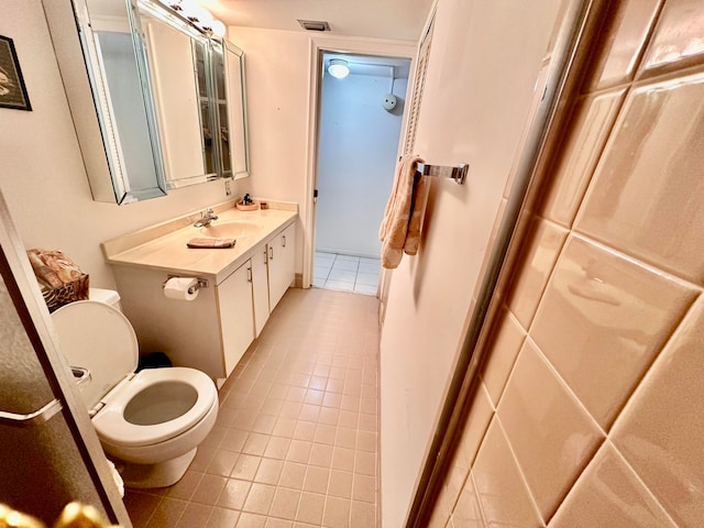 bathroom featuring vanity, tile patterned flooring, and toilet