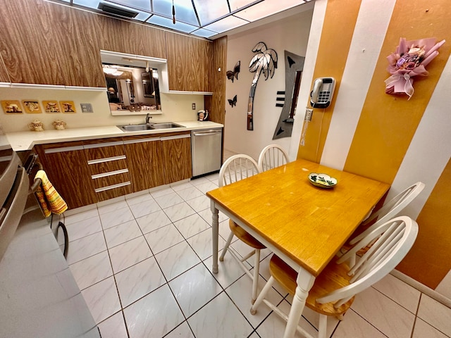 kitchen featuring light tile patterned flooring, sink, and stainless steel dishwasher