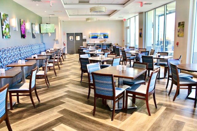 dining room with hardwood / wood-style flooring and a raised ceiling