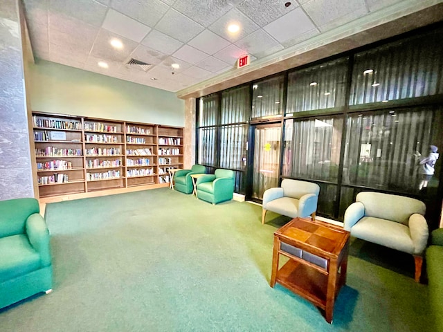 sitting room featuring a drop ceiling and carpet floors