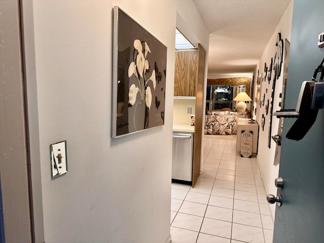 hallway featuring a textured ceiling and light tile patterned floors