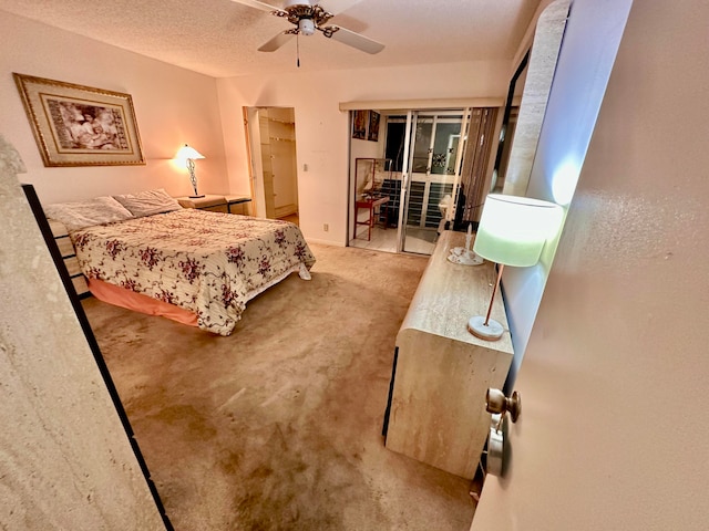 carpeted bedroom with a textured ceiling, ceiling fan, and a closet