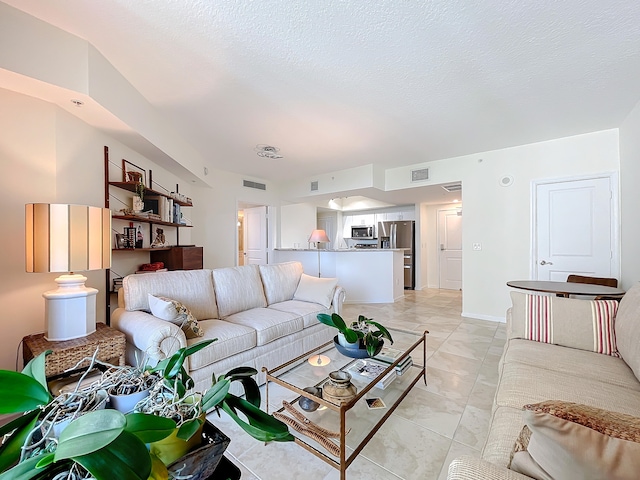 living room with light tile patterned flooring and a textured ceiling