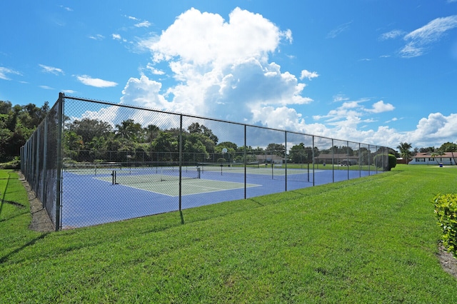 view of tennis court with a yard