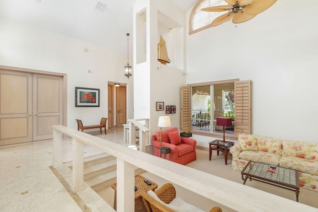 living room featuring ceiling fan and a high ceiling