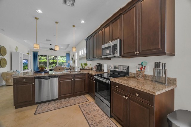 kitchen featuring appliances with stainless steel finishes, light stone counters, kitchen peninsula, light tile patterned floors, and ceiling fan