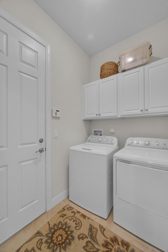 laundry room with washer and clothes dryer and cabinets