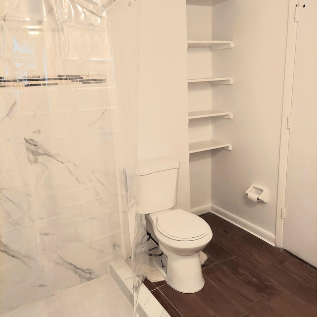 bathroom with toilet, walk in shower, and wood-type flooring