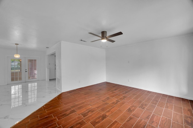 empty room featuring french doors, ornamental molding, hardwood / wood-style flooring, and ceiling fan