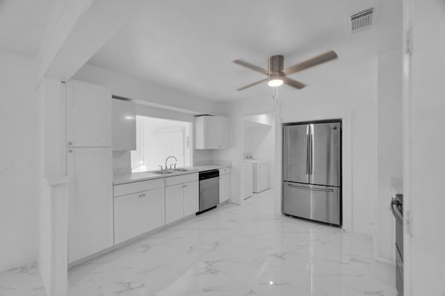 kitchen with white cabinets, ceiling fan, sink, stainless steel appliances, and washer and clothes dryer