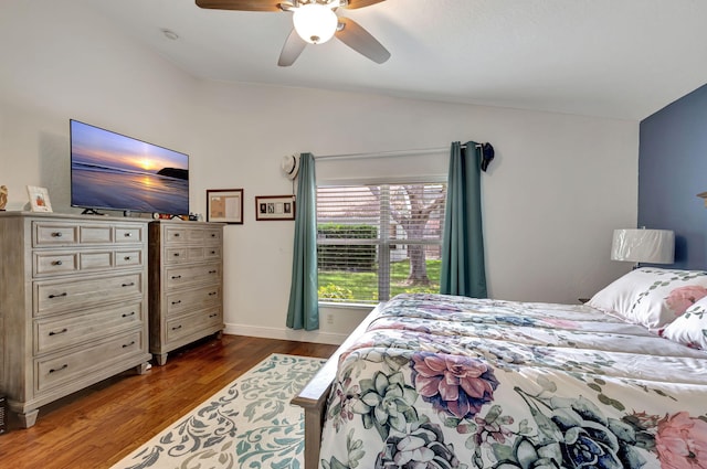 bedroom with ceiling fan, vaulted ceiling, and dark wood-type flooring