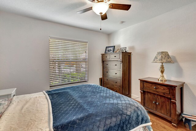 bedroom with light hardwood / wood-style floors and ceiling fan