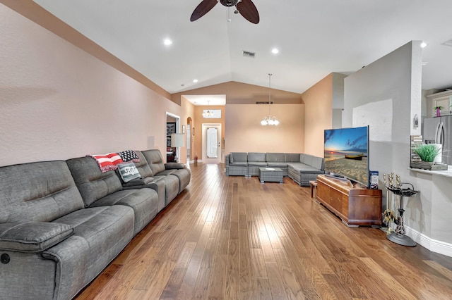 living room featuring ceiling fan with notable chandelier, vaulted ceiling, and hardwood / wood-style floors