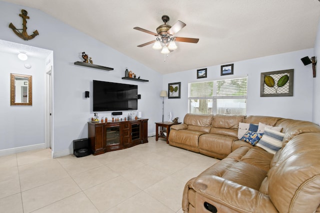 living room with ceiling fan, vaulted ceiling, and light tile patterned floors