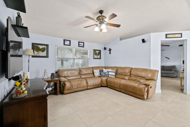 living room with a textured ceiling, light tile patterned floors, and ceiling fan