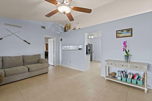 living room featuring ceiling fan, light tile patterned flooring, a textured ceiling, and lofted ceiling