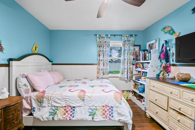 bedroom with a textured ceiling, dark hardwood / wood-style floors, and ceiling fan