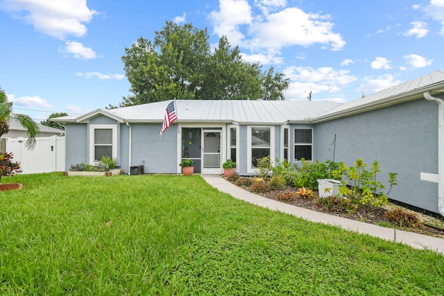 back of house with central AC unit and a lawn